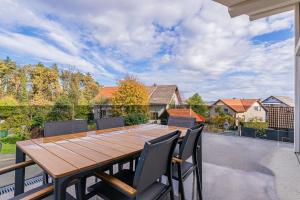a wooden table and chairs on a patio at Ski Apartments Frigo Pohorje 1 and 2 - Happy Rentals in Maribor