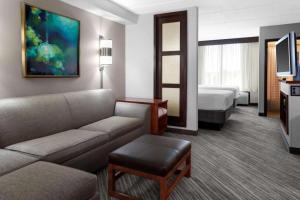 a hotel room with a couch and a bed at Oklahoma City Airport Hotel & Suites Meridian Ave in Oklahoma City