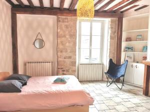 Habitación con cama y silla. en Le Cosy Sénonais, en Sens
