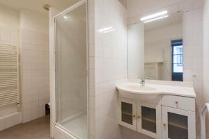 y baño blanco con lavabo y ducha. en Saint-Thomas 1- Appt moderne dans Strasbourg en Estrasburgo