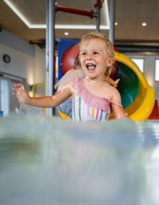 Una bambina sta giocando in acqua di H2O Hotel-Therme-Resort, für Familien mit Kindern a Bad Waltersdorf