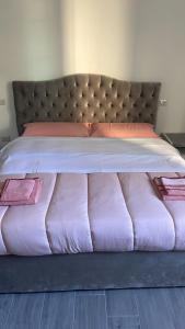 a large bed with pink sheets and pink pillows at Appartamento Tortona in Tortona