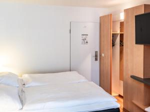 a bedroom with a bed and a flat screen tv at B&B Hotel Aachen-Hbf in Aachen