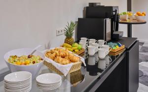 a breakfast buffet with fruit and pastries on a counter at Holiday Inn Express Frankfurt Airport, an IHG Hotel in Mörfelden-Walldorf