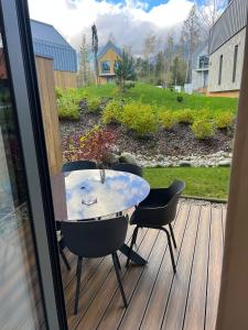 un tavolo e sedie seduti su una terrazza in legno di TATRYSTAY Brezy Luxury Apartment a Stará Lesná Altre 19 foto