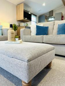 uma sala de estar com um sofá e um repousa-pés em Beach Grove em Scarborough