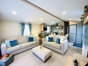 a living room with two couches and a kitchen at Beach Grove in Scarborough