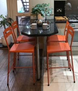 a kitchen with a table with orange chairs and a counter at Apartment One Hull in Hull