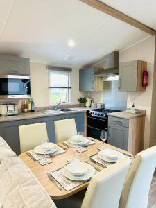 a kitchen with a wooden table with chairs and a dining room at Beach Grove in Scarborough