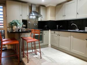 cocina con armarios blancos, mesa y sillas en Apartment One Hull en Hull