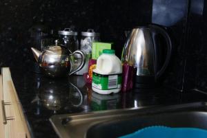 a kitchen counter with a sink and a jug of milk at Apartment One Hull in Hull
