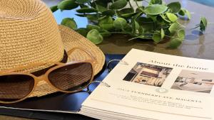 a hat and sunglasses sitting on a table with a book at Poolside at Magenta in Magenta