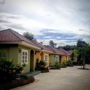 a row of yellow houses with red roofs at Wangpla Villa Resort in Nakhon Sawan