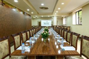a long table in a room with chairs and a screen at Royal Plaza by Stellar Hotels, Yerevan in Yerevan