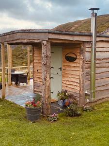 a wooden cabin with a patio and a table at The original Sleeping Giant Lodge - Farm Stay, meet the animals in Ystradgynlais