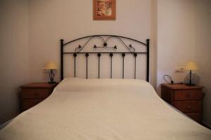 1 dormitorio con 1 cama blanca grande y 2 mesitas de noche en Apartamento Cadiz Bajo, en Conil de la Frontera