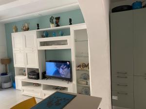 a living room with a tv in a white cabinet at Cà Rara pied à terre in Marina di Carrara