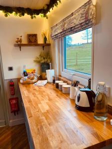 a kitchen with a wooden counter top with a window at The original Sleeping Giant Lodge with hot tub & Alpacas in Ystradgynlais +33 photos