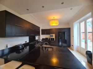 a kitchen with black cabinets and a black counter top at 23 HeadsLane in Hessle