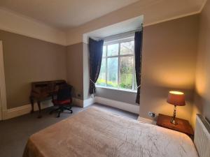 a bedroom with a bed and a desk and a window at 23 HeadsLane in Hessle
