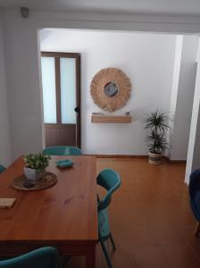 ein Esszimmer mit einem Holztisch und blauen Stühlen in der Unterkunft Casa en la playa, Aldea Coast in San Nicolás