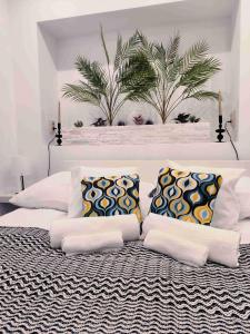 a white bedroom with a large bed with pillows at Baky House in Balatonlelle