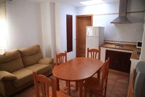 コニル・デ・ラ・フロンテーラにあるApartamento Cadiz Bajoのリビングルーム(ソファ、テーブル付)、キッチンが備わります。
