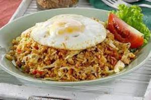 a plate of food with eggs on top of rice at The Green Ponci Bedugul in Baturiti