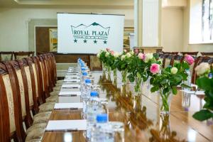 a long table with vases of flowers on it at Royal Plaza by Stellar Hotels, Yerevan in Yerevan
