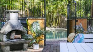 CopacabanaCoastal Cottage with Pool at Copacabana的游泳池旁带石头壁炉的花园