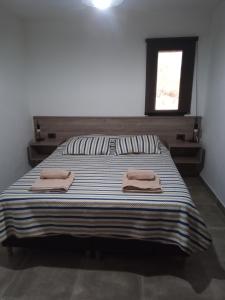 a bedroom with a bed with two towels on it at Casa Moderna in Mina Clavero