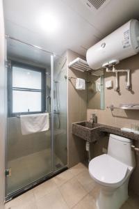 a bathroom with a shower and a toilet and a sink at WESU Weisu Service Apartment - Shenzhen University Nanshan Science and Technolog Park in Shenzhen