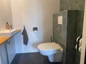 bagno con servizi igienici bianchi e lavandino di Brour&Bos a Laren