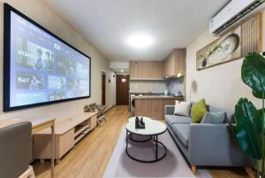 a living room with a couch and a flat screen tv at WESU Weisu Service Apartment - Shenzhen University Nanshan Science and Technolog Park in Shenzhen