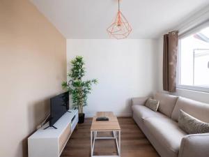 a living room with a couch and a table at Le Barr - Magnifique petit T2 refait à neuf in Strasbourg