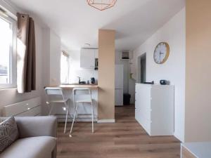 a kitchen and living room with a table and chairs at Le Barr - Magnifique petit T2 refait à neuf in Strasbourg