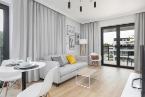 a white living room with a couch and a table at Shellter Apartments 117 H - by Jantar Apartamenty in Rogowo