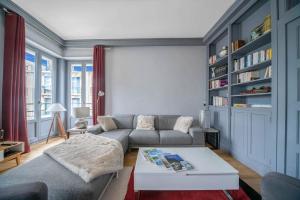 een woonkamer met een bank en een salontafel bij L'ANTHRACITE - Proche Opéra & Centre-ville in Vichy