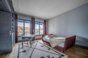 een slaapkamer met een bed, een tafel en een raam bij L'ANTHRACITE - Proche Opéra & Centre-ville in Vichy