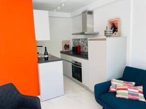 kuchnia z białymi szafkami i pomarańczową ścianą w obiekcie Top-Apartment near Yumbo w mieście Playa del Ingles +25 zdjęć