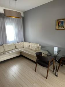 a living room with a white couch and a glass table at Mini Art House in Nicosia