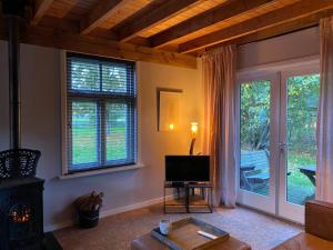 een woonkamer met een televisie en een open haard bij Brour&Bos in Laren