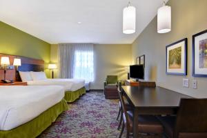 リッジランドにあるTownePlace Suites by Marriott Jackson Ridgeland/The Township at Colony Parkのベッド2台とデスクが備わるホテルルームです。