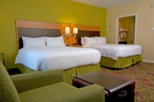 a hotel room with two beds and a chair at TownePlace Suites by Marriott Jackson Ridgeland/The Township at Colony Park in Ridgeland