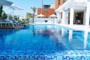 een groot zwembad met blauwe tegels erop bij Vivo Mare Beachfornt Villas - Azure in Ayia Napa