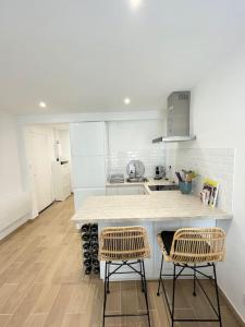 a kitchen with a counter and two chairs in it at Appartement Cosy Aix en Provence in Aix-en-Provence