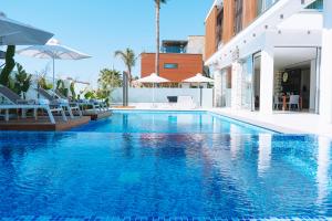 een zwembad met blauw water in een gebouw bij Vivo Mare Beachfornt Villas - Azure in Ayia Napa