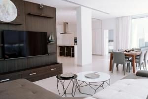 a living room with a couch and a flat screen tv at Vivo Mare Beachfornt Villas - Azure in Ayia Napa