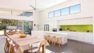 Una cocina y un comedor con mesa y sillas. en Killcare Beach Abode with AC, en Killcare