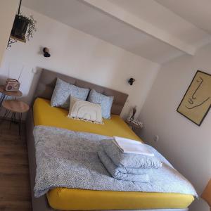 a bedroom with a yellow bed with a blanket at Stan na dan Jungle in Bajina Bašta
